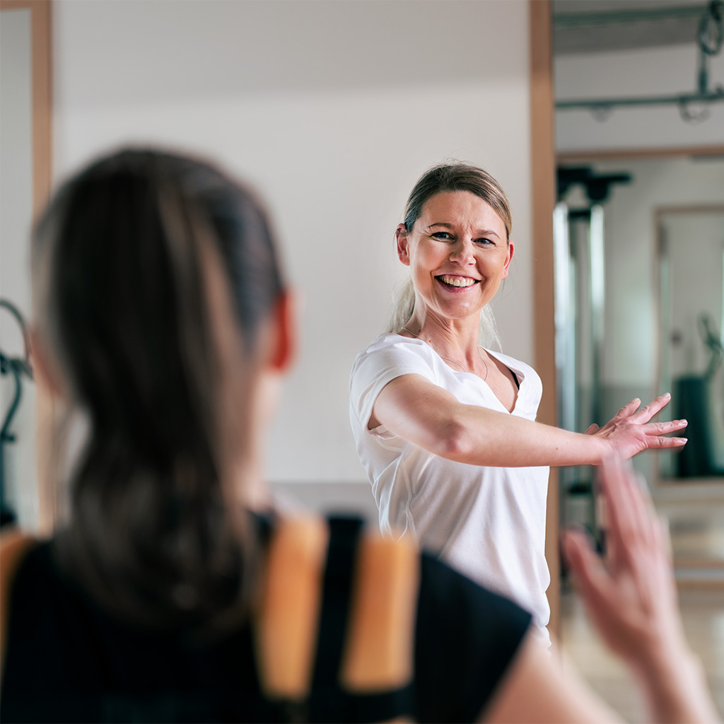 Mutter im Fitnesskurs, fokussiert und entspannt, um ihre Fitness zu steigern.