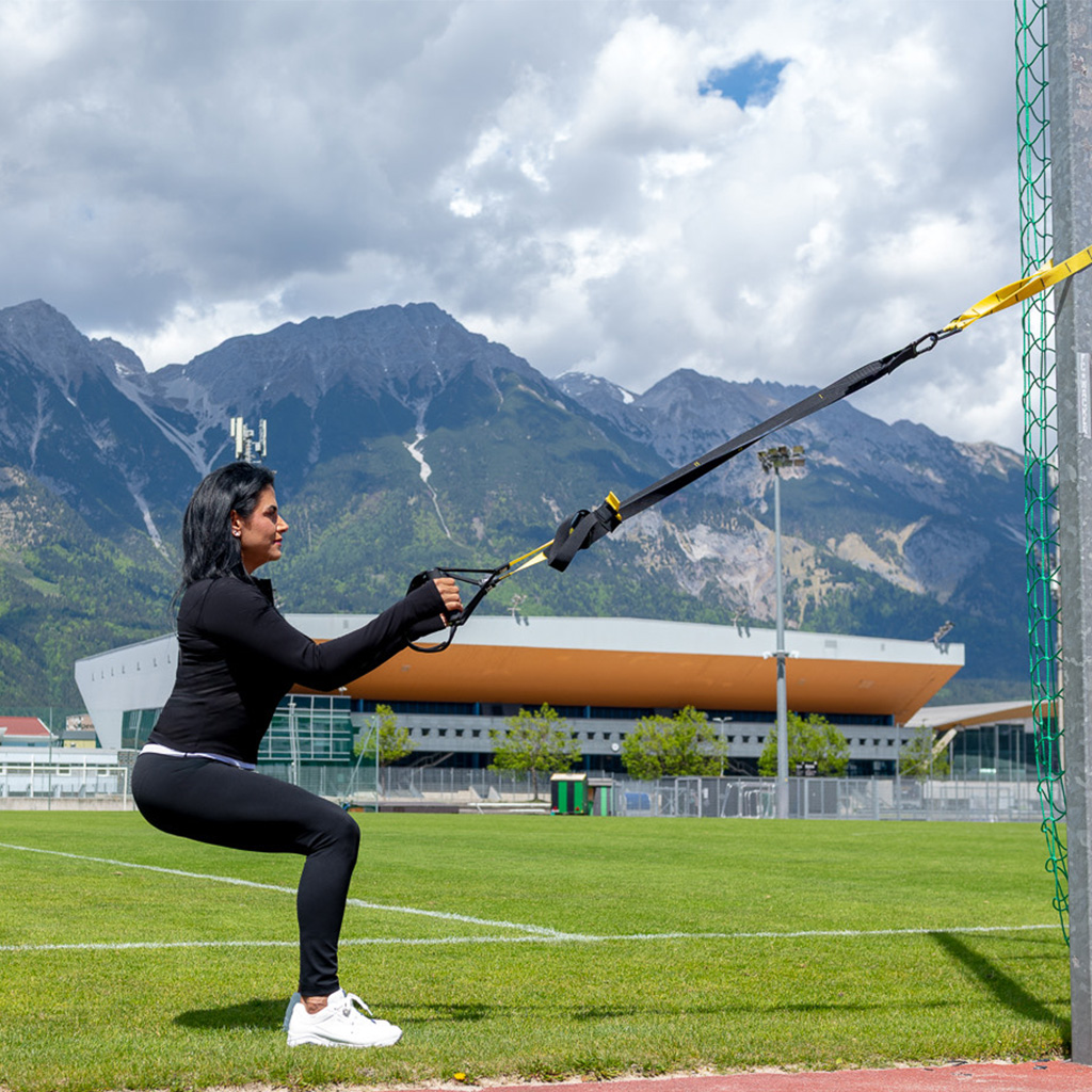 Pamela in tiefer Hocke mit TRX-Bändern.